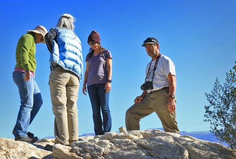 Four adults stand on rock overlooking valley