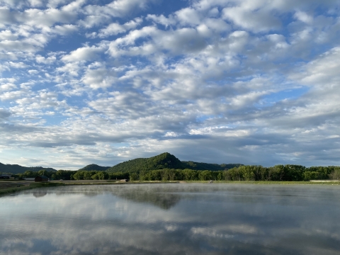 Looking at a hatchery pond with bluffs in the background on a beautiful cloudy day