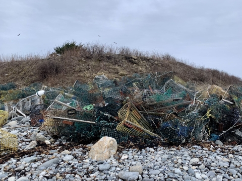 mangled pile of abandoned lobster traps on rises up to three feet on the shore of a remote sea island
