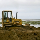 Bulldozer moves dirt on coast